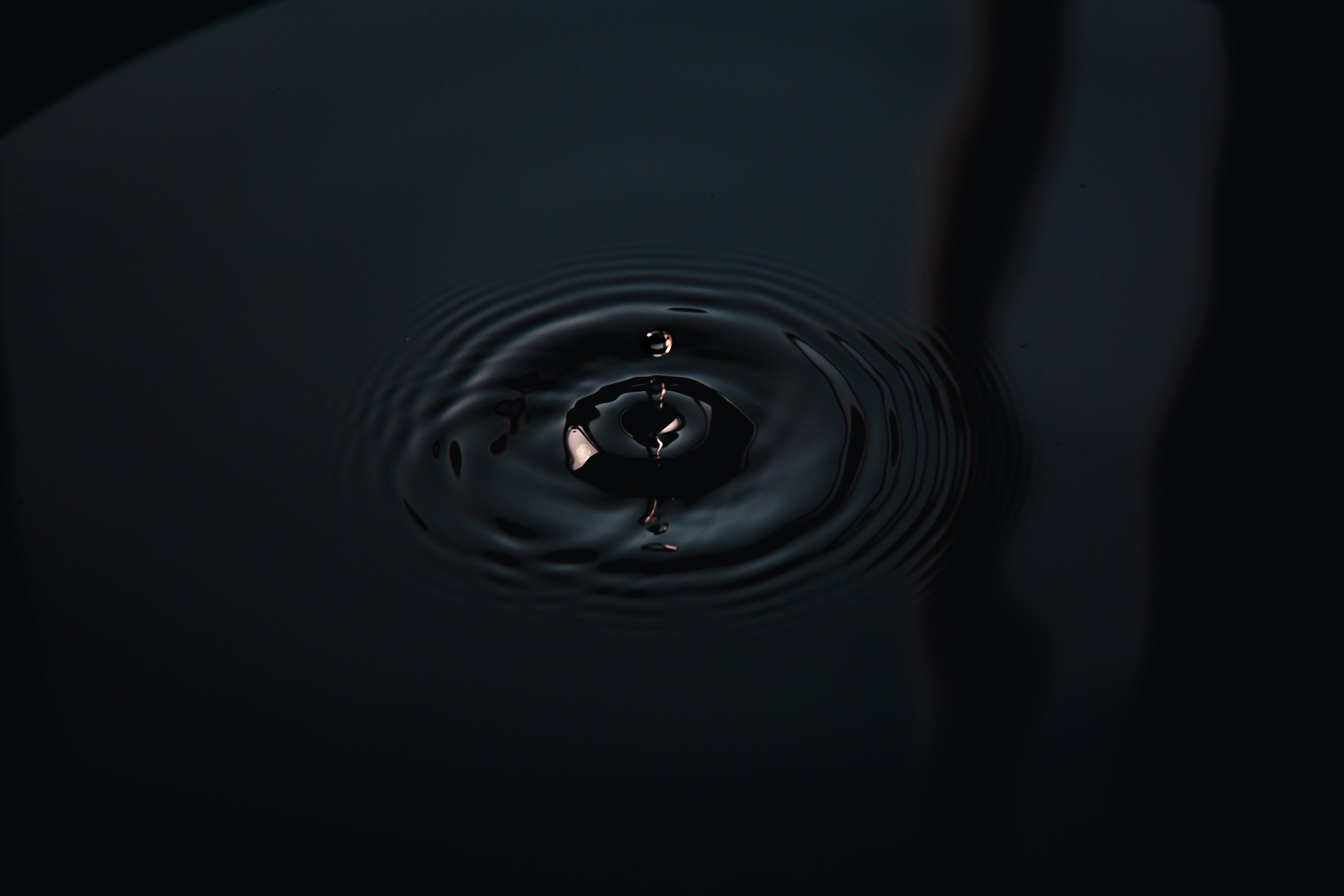 Wassertropfen in dunkles Wasser