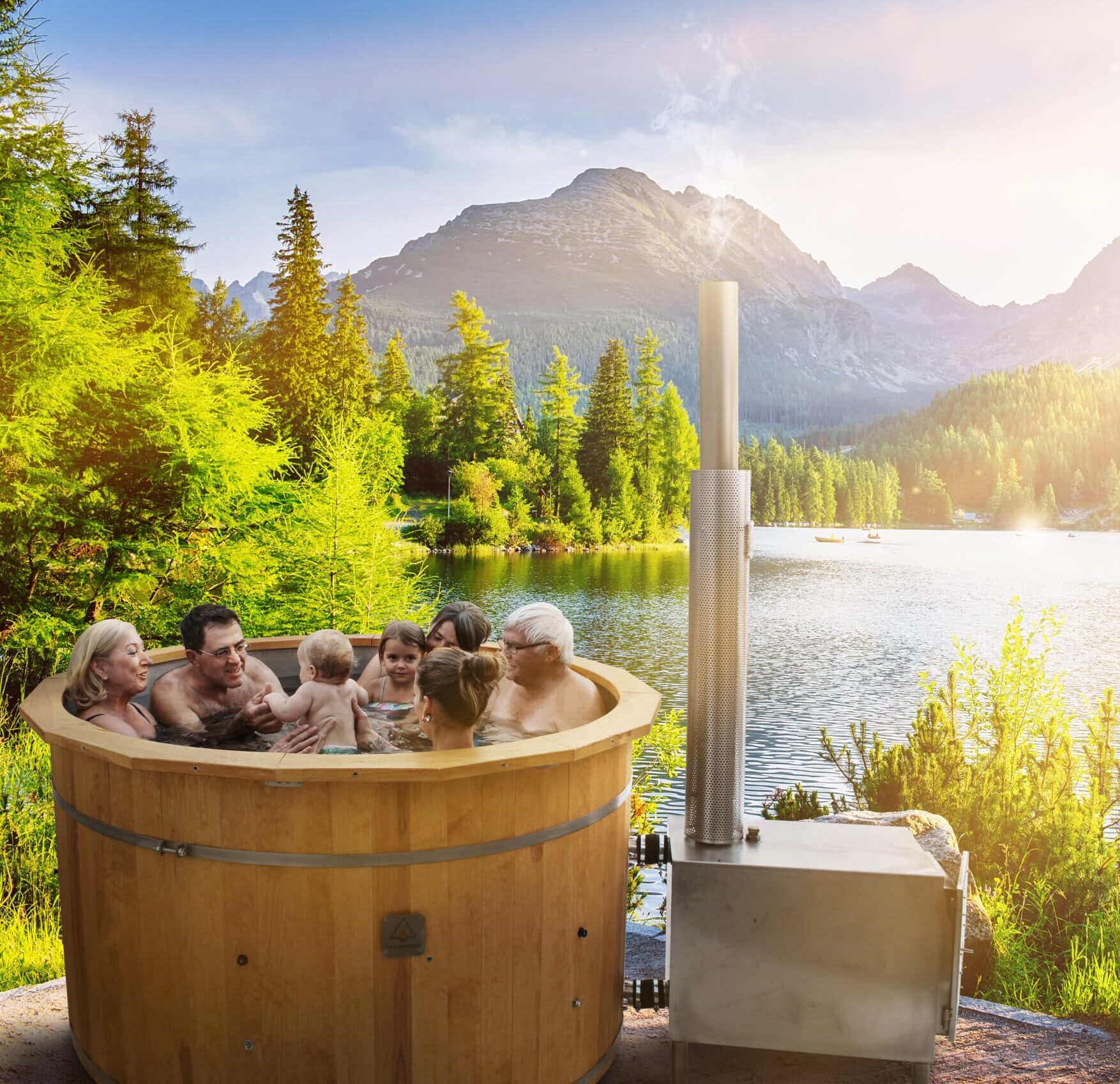 Familie badet in holzbeheizten Badefass von Feuerwasser am See