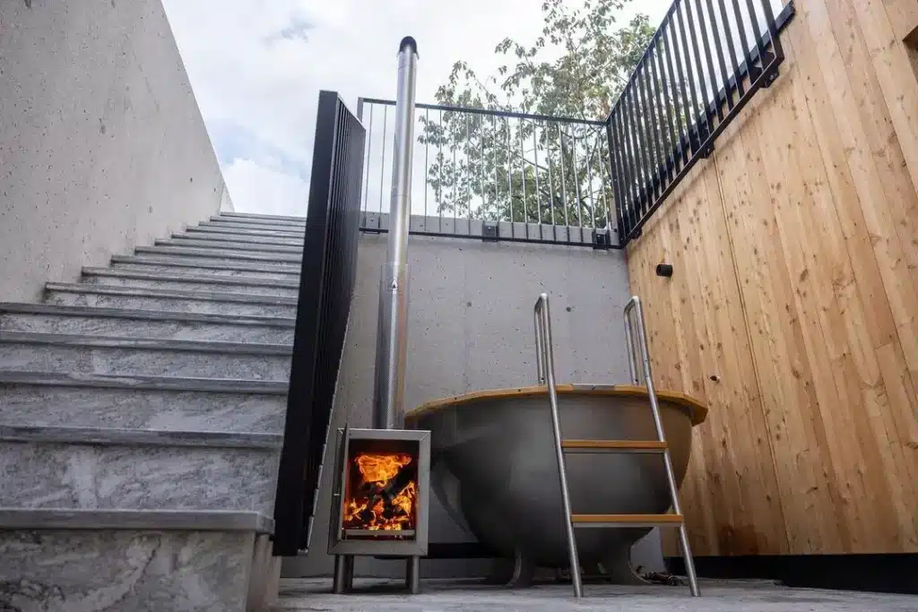 Badezuber von Feuerwasser neben einer Stiege mit brennendem Ofen