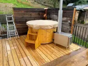 Badefass von Feuerwasser mit Holzofen auf einer nassen Terrassenplattform