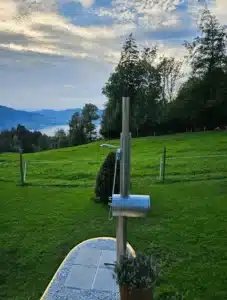 Feuerwasser Edelstahl-Gartendusche auf Bergwiese mit Blick auf See und Wälder
