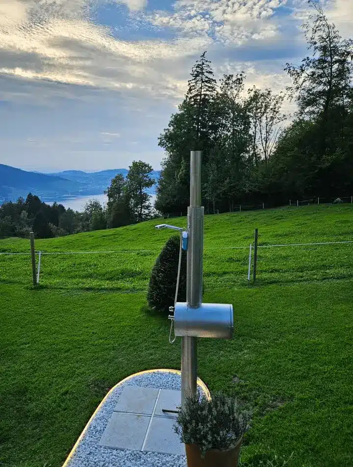 Feuerwasser Edelstahl-Gartendusche auf Bergwiese mit Blick auf See und Wälder
