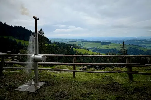 Feuerwasser Edelstahl-Gartendusche im Einsatz vor weitem Berg- und Wiesenpanorama