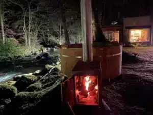 Hot Tub Holzofen am nächtlichen Flussufer, Feuer brennt