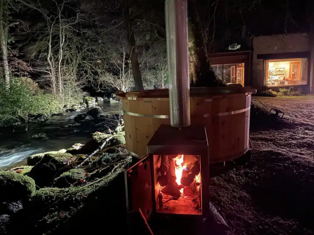 Hot Tub Holzofen am nächtlichen Flussufer, Feuer brennt