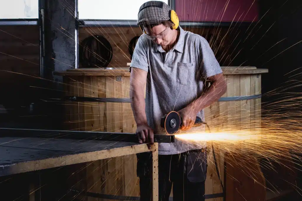 Martin Auer bearbeitet Edelstahlteil für Feuerwasser Badefass, Funkenflug in der Produktion