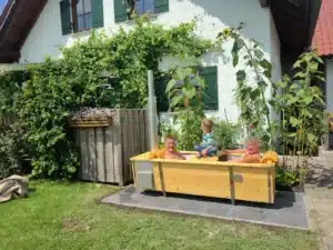 Outdoor-Badewanne von Feuerwasser im Garten mit badender Familie