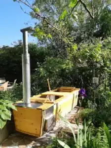 Outdoor-Badewanne von Feuerwasser im Frühling in grünem Garten