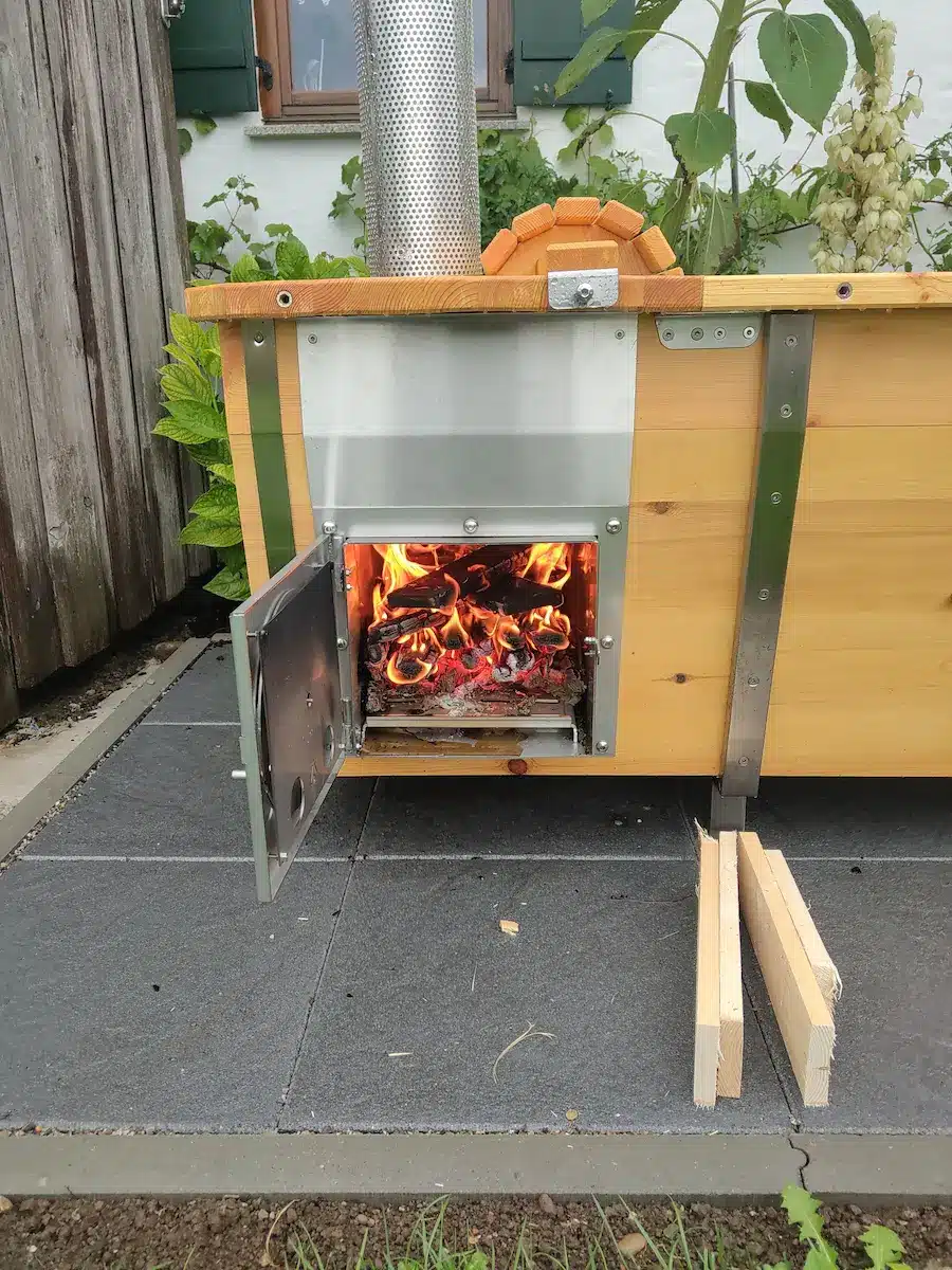 Holzofen der Outdoor-Badewanne aus V4A-Edelstahl und Kieferholz mit offenem Feuer