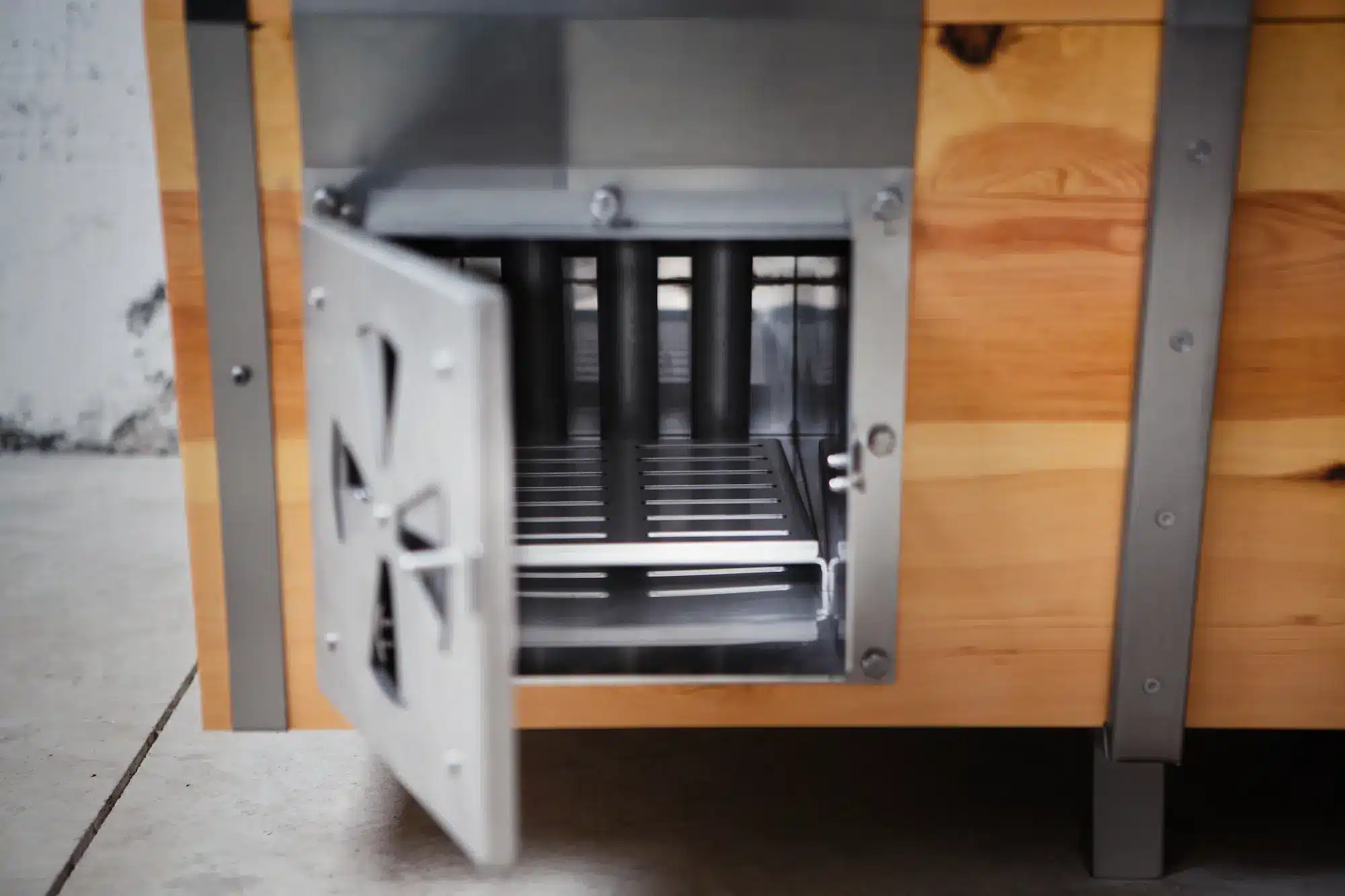 Detailaufnahme des geöffneten Holzofens der Outdoor-Badewanne von Feuerwasser