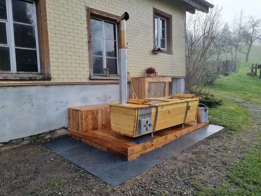 Beheizbare Outdoor-Badewanne von Feuerwasser auf Holzpodest im Garten