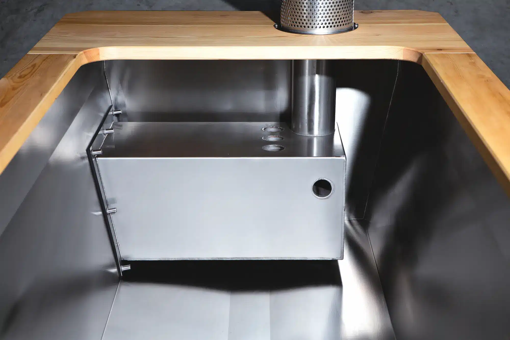 Innenraum der Outdoor-Badewanne von Feuerwasser mit integriertem Innenofen aus V4A-Edelstahl und Kiefer-Vollholz-Rand