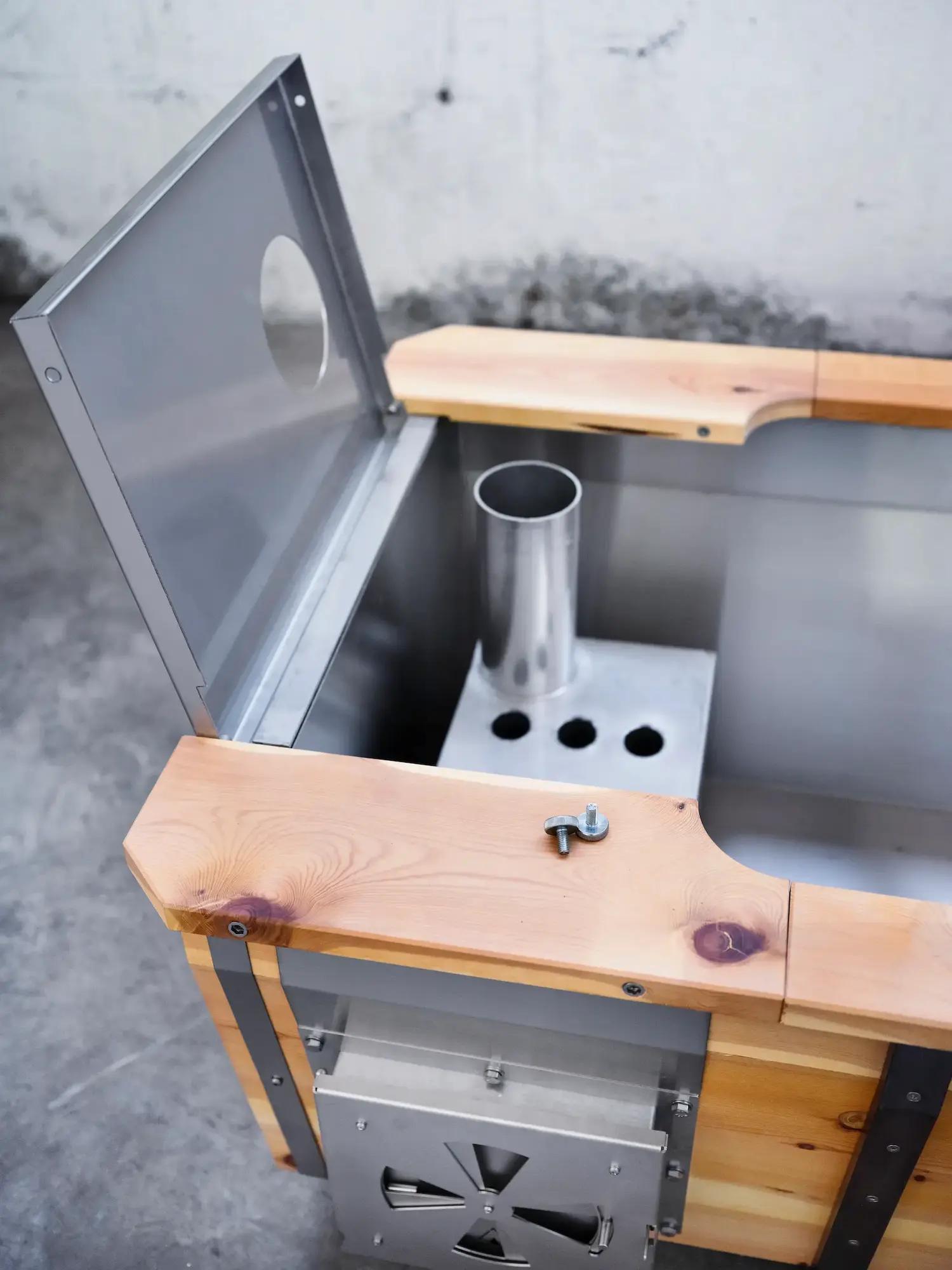 Outdoor-Badewanne von Feuerwasser mit geöffneter Ofenabdeckung, sodass der Ofenbereich sichtbar ist