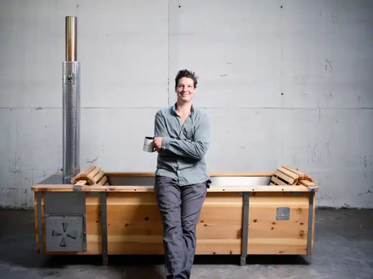 Martin Auer, Gründer und Inhaber von Feuerwasser, lehnt lässig an einer Outdoor-Badewanne