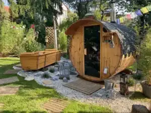 Outdoor-Badewanne von Feuerwasser neben Sauna in naturbelassenem Garten