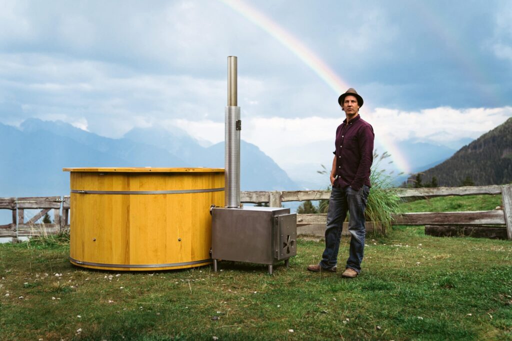Founder of Feuerwasser Martin Auer stands next to a hot tub